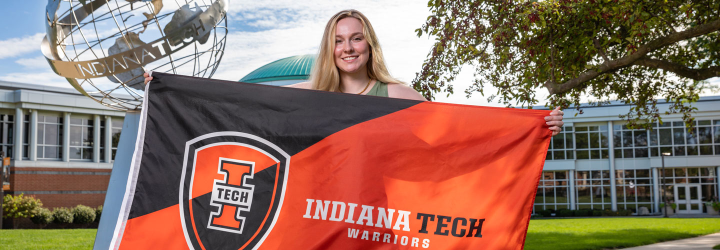 Student holding Indiana Tech flag
